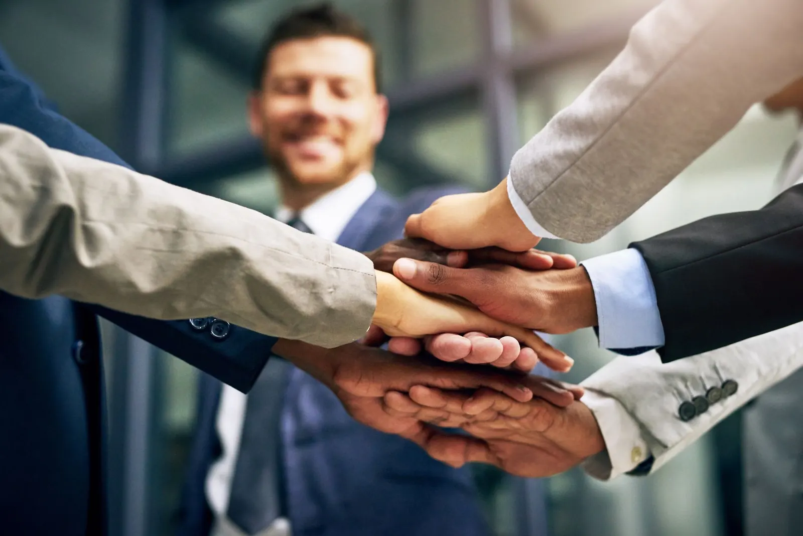 Un groupe de gens d’affaires mettent leurs mains ensemble.